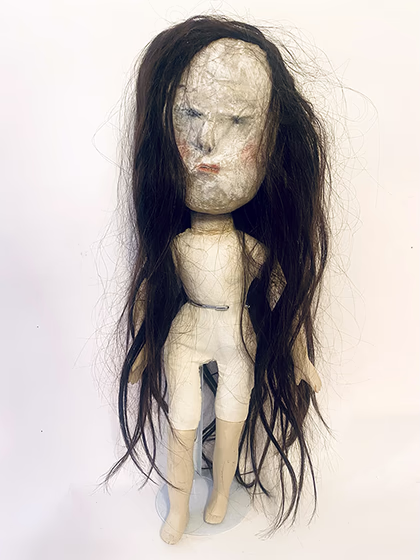 Uncanny girl doll with long dark brown hair