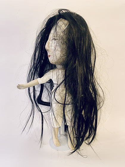 Uncanny girl doll with long dark brown hair